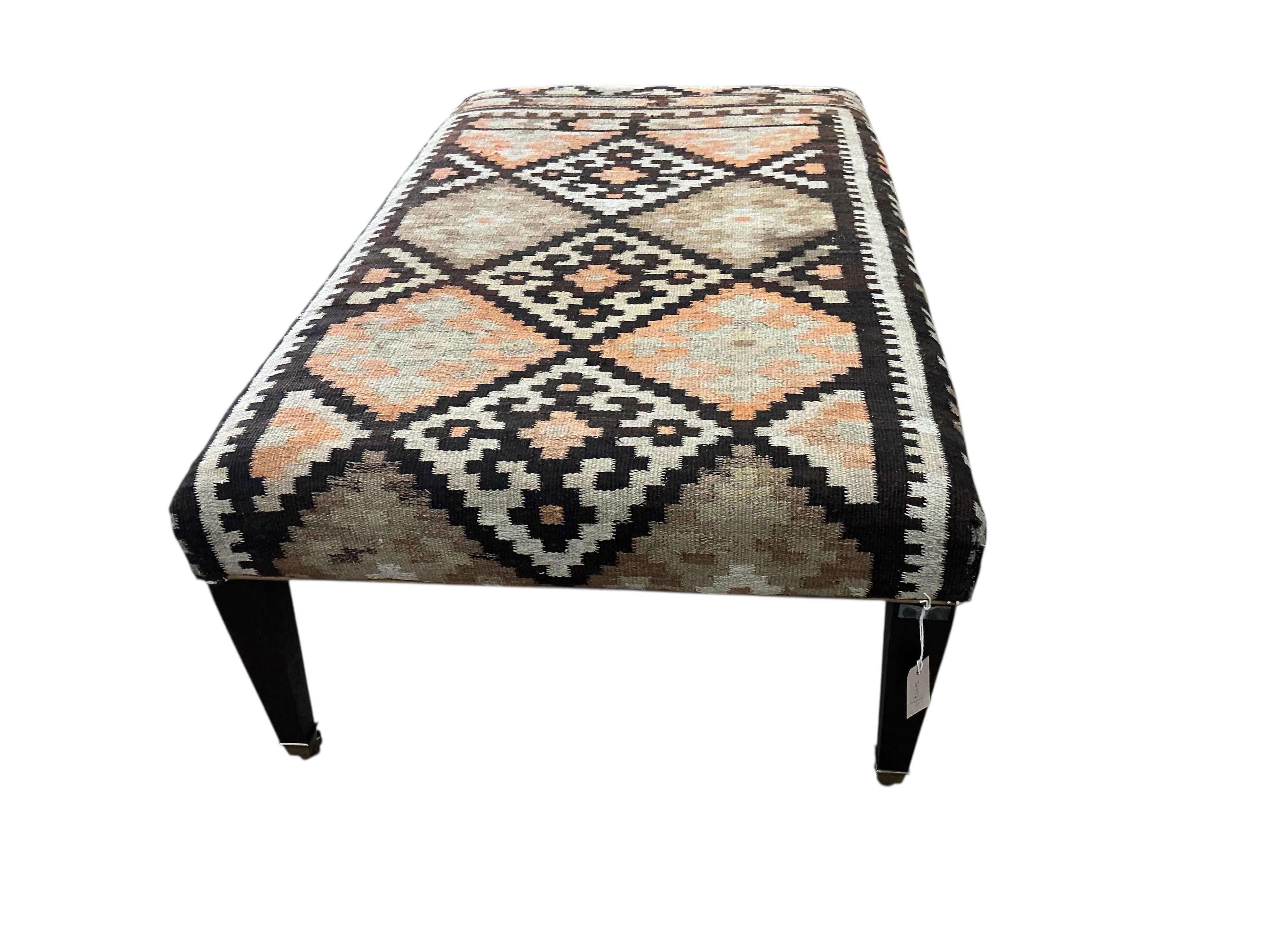 A large rectangular coffee table / footstool with polychrome Kilim upholstered top, width 143cm, depth 84cm, height 48cm